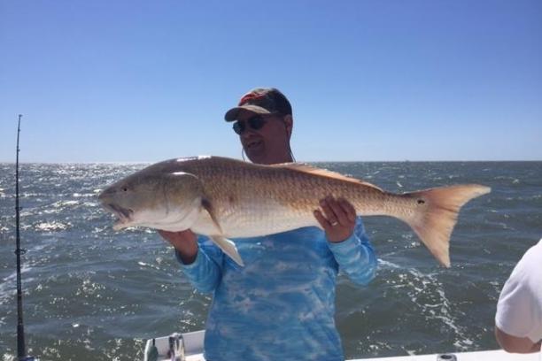 a man holding a fish in the water