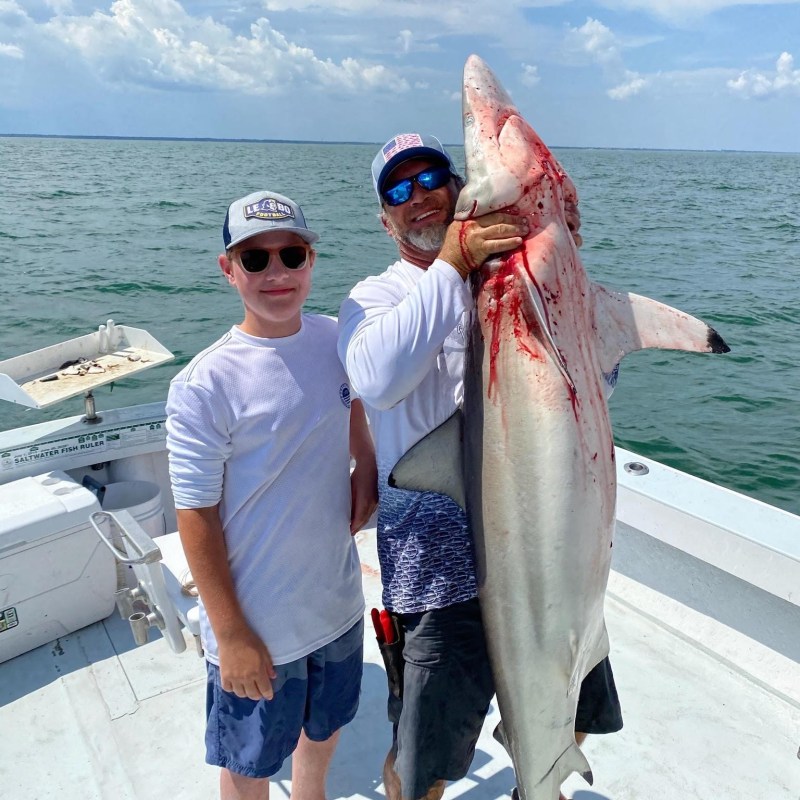 a man holding a fish in the water
