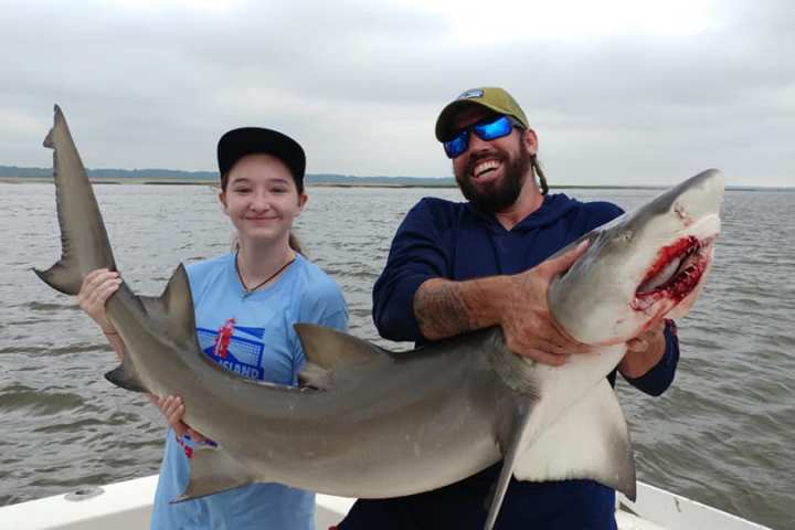 a person holding a fish in the water