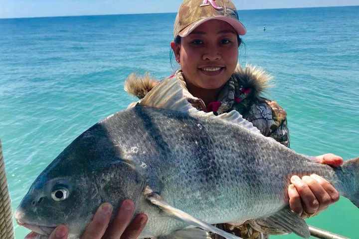 a man standing next to a body of water