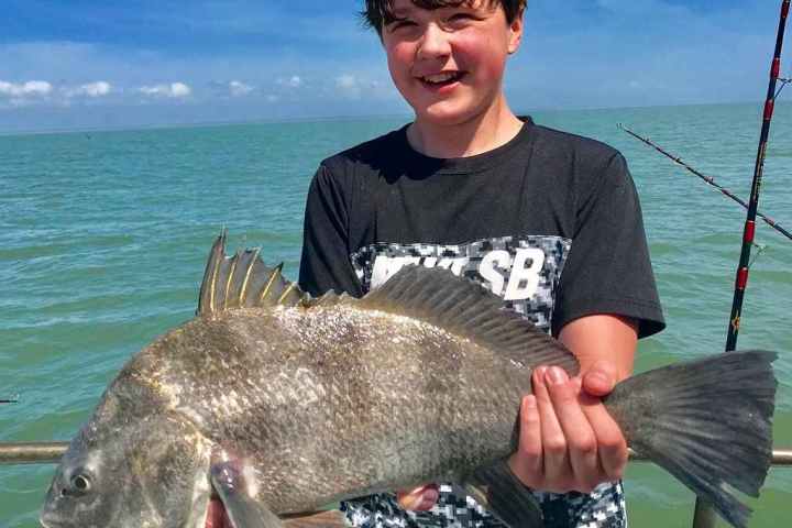 Joseph Castanon holding a fish in the water