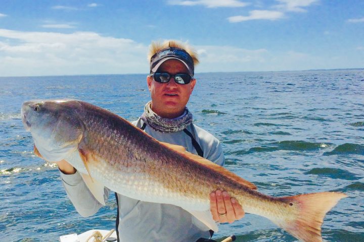 a person holding a fish in the water