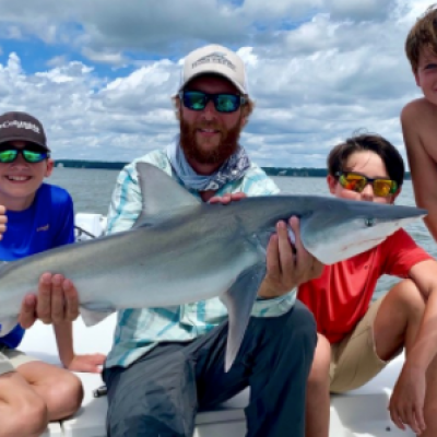 a group of people sitting next to a body of water