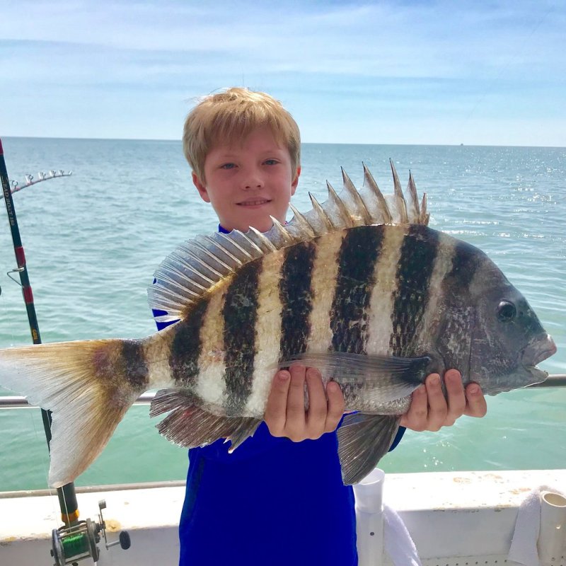a young boy holding a fish in the water