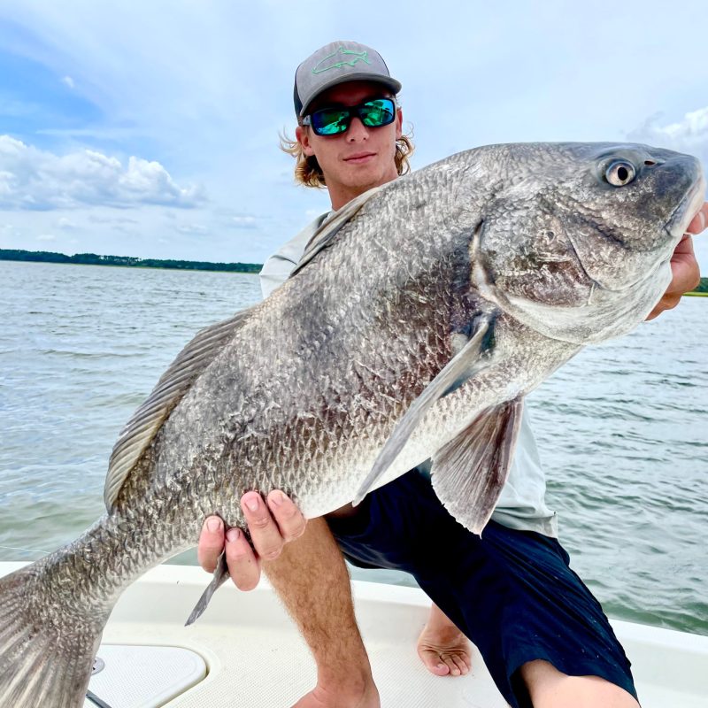 a person holding a blackdrum in the water