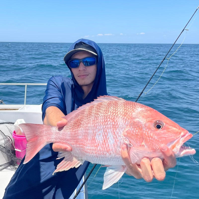 a person holding a fish in the water