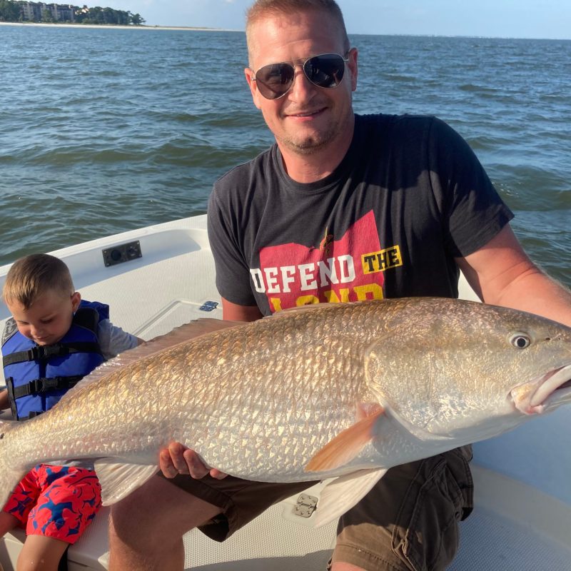 a man holding a fish in the water